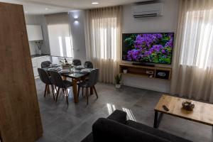 a living room with a dining table and a tv at Apartments Porta Maggiore in Koper