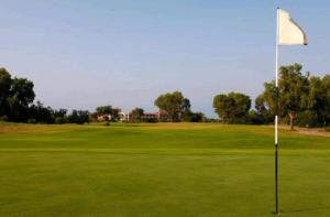 um campo de golfe com uma bandeira no verde em TRIPLEX LA MARINA SAIDIA em Saïdia