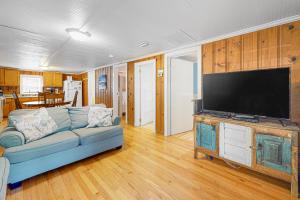 a living room with a blue couch and a flat screen tv at Cozy Corner in Folly Beach