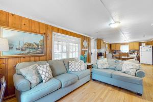 a living room with two blue couches and a kitchen at Cozy Corner in Folly Beach