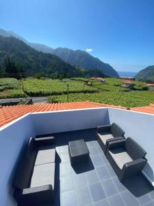 un patio con 2 asientos y vistas a la montaña en Sebastian's Apartment, en São Vicente