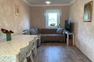 ein Wohnzimmer mit 2 Tischen und einem Sofa in der Unterkunft Grandma's House in Radlje ob Dravi