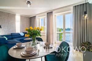 a living room with a table and a blue couch at WIDOKOWO Apartamenty in Ełk