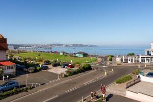 eine Stadtstraße mit auf einem Parkplatz geparkten Autos in der Unterkunft The Torland Hotel - Paignton Seafront, Guaranteed free parking in Paignton