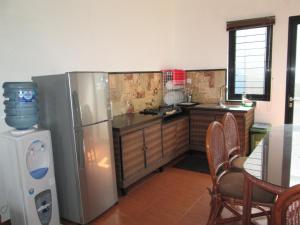 a kitchen with a stainless steel refrigerator and a table at Osmond Villa Resort in Lembang