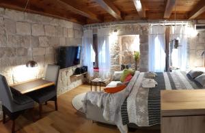 um quarto com uma cama grande e uma parede de pedra em Old town St. Roko em Korčula