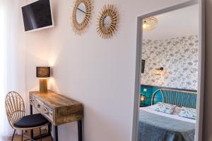 a bedroom with a bed and a desk and a mirror at "Cap Riviera" Hotel & Restaurant Saint Aygulf in Saint-Aygulf +100 photos