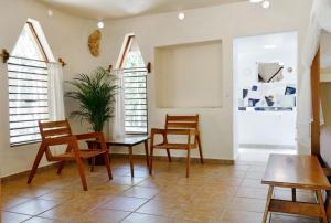 a living room with chairs and a table and windows at Villas Ecotucan in Bacalar