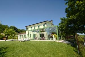 a white house with a glass extension on a yard at B&B Ai Filari in Baone