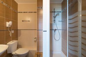 W łazience znajduje się prysznic, toaleta i umywalka. w obiekcie "Cap Riviera" Hotel & Restaurant Saint Aygulf w mieście Saint-Aygulf