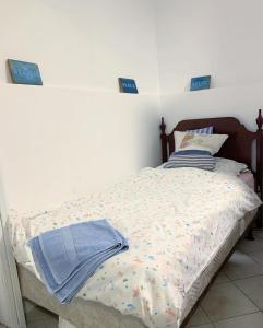 a bed in a bedroom with two blue signs on the wall at Erdei házak in Csopak