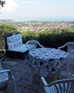 una mesa, sillas y un banco en un patio en Erdei házak, en Csopak