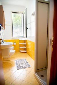 een badkamer met een wastafel, een toilet en een raam bij TropeaCharmet PARKING FREE in Tropea