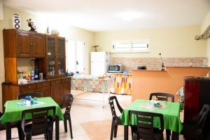 una cocina con 2 mesas con mantel verde en TropeaCharmet PARKING FREE, en Tropea