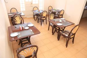 comedor con mesas y sillas de madera en The 4 JS Bed and Breakfast Emali, en Emali