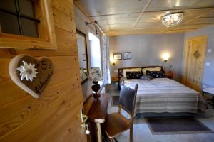 a bedroom with a bed and a wooden wall at Maison Du-Noyer Chambres et Tables d'Hotes in Aosta