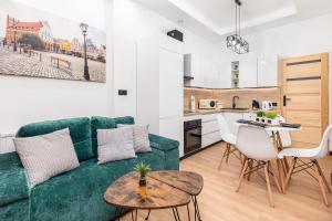 un soggiorno con divano verde e una cucina di Bm apartamenty Wały Chrobrego Radogoska Parking a Stettino