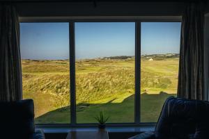 a room with a window looking out at a golf course at The Links Apartment Portrush in Portrush