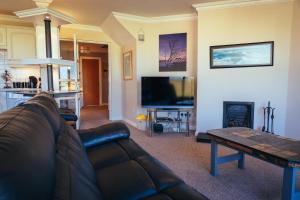 a living room with a couch and a flat screen tv at The Links Apartment Portrush in Portrush