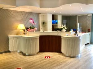 a lobby with a bar with two white stools at Hotel Alfieri in Sirmione