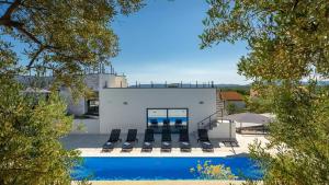 a house with a swimming pool next to a building at Luxury Villa Subventus in Krk