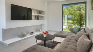 a living room with a couch and a tv at Luxury Villa Subventus in Krk