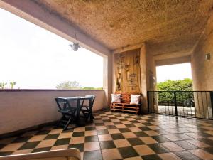 a balcony with a table and a checkered floor at Frida casavacanze in Castellammare del Golfo