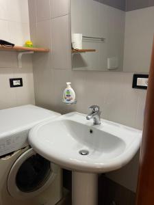 ein Badezimmer mit einem Waschbecken und einer Waschmaschine in der Unterkunft La casa di nonna rosetta in Cirò Marina