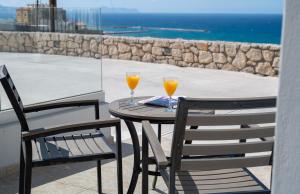 2 bicchieri di succo d'arancia seduti su un tavolo sul balcone di George's Apartment a Rethymno