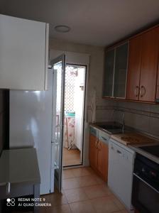 a kitchen with a refrigerator and a door to a yard at Precioso ático con solárium y vistas fantásticas in Playa Honda