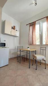a kitchen with a table and chairs in a room at Apartments Raos Podgora in Podgora