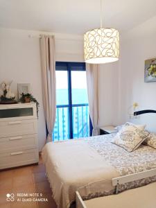 een slaapkamer met een bed en een groot raam bij Precioso ático con solárium y vistas fantásticas in Playa Honda