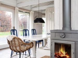 a fireplace in a dining room with a table and chairs at 5 person holiday home in Hornb k in Hornbæk