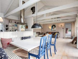 a dining room with a white table and blue chairs at 5 person holiday home in Hornb k in Hornbæk