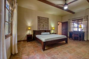 a bedroom with a bed and two tables and a window at La Veranera, Playa El Coco in San Juan del Sur +58 photos