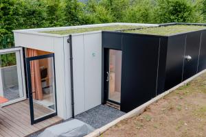 a small house with a green roof at Au fond du jardin in Profondeville