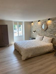 - une chambre avec un grand lit et un mur en briques dans l'établissement Marseille City Chambres&Appartements, à Marseille