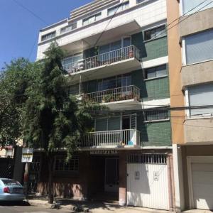an apartment building with a tree in front of it at Nebraska Suites WTC in Mexico City