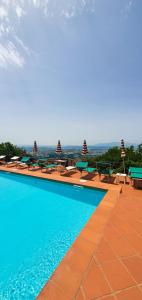 a large swimming pool with tables and benches on a building at Bellavista Hotel & Osteria in Lamporecchio