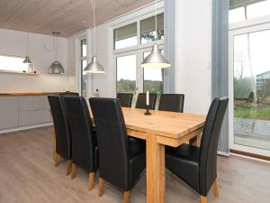 a dining room with a wooden table and black chairs at 5 star holiday home in Knebel in Knebel