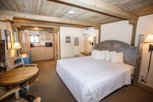 a bedroom with a large white bed and a table at Chama Trails Motel in Chama