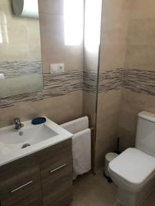 een badkamer met een wastafel, een toilet en een spiegel bij Apartamento Cervera in Torremolinos +13 foto's
