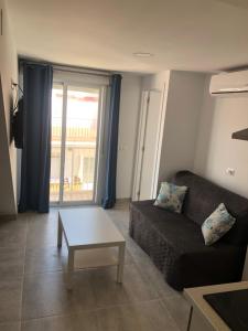 een woonkamer met een bank en een salontafel bij Apartamento Cervera in Torremolinos