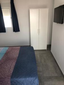 een slaapkamer met een bed en een witte kast bij Apartamento Cervera in Torremolinos
