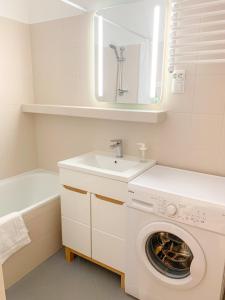 a white laundry room with a sink and a washing machine at Między górami. Apartament w Cisnej in Cisna