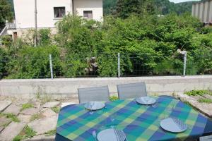 Gite de l'ancien Moulin في لو فال ديه آجول: طاولة بها قماش منقوش أزرق وأخضر