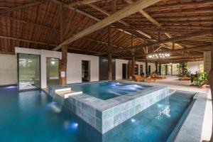 a pool in a house with a stone wall at Resort Fazenda 3 Pinheiros in Engenheiro Passos