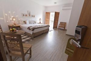 a bedroom with a bed and a table and a door at Resort Fazenda 3 Pinheiros in Engenheiro Passos