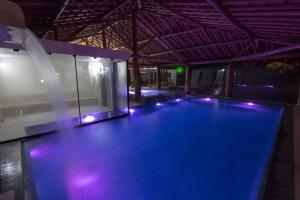 a large swimming pool with lights in a building at Resort Fazenda 3 Pinheiros in Engenheiro Passos