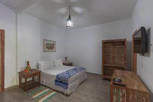 a bedroom with a bed and a flat screen tv at Resort Fazenda 3 Pinheiros in Engenheiro Passos